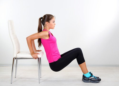 Жена прави на стол лицеви опори