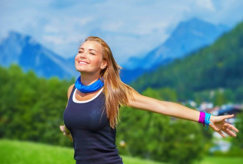 Като пиете повече вода: Една млада и усмихната руса жена с разперени ръце