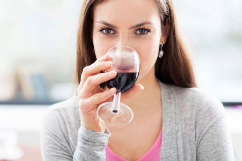 Жена пие чаша червено вино