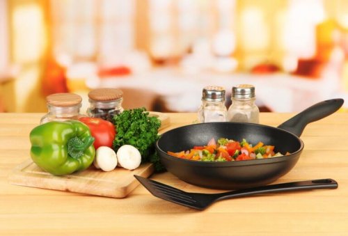холестеролът: тиган със зеленчуци на масата, един домат, чушка и магданоз