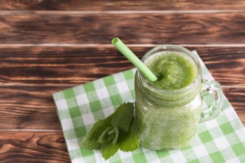 Премахване на токсините: шейк от мента в буркан със сламка на маса и листа от мента