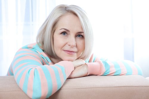 При менопауза: жена на около 50, руса, облегнала се е на диван.