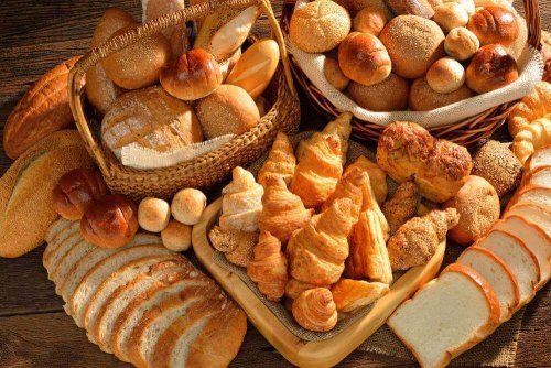 Различни видове хляб и кроасани в кошници и на маса