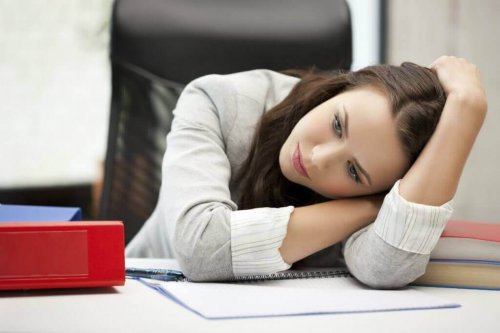 Заболяването хипотиреоидизъм: една млада жена се е облегнала на бюро в офиса
