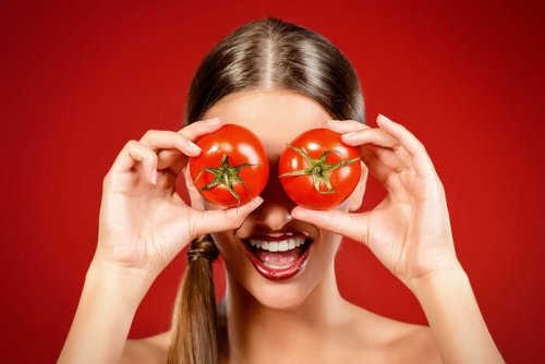 Лице на млада жена, сложила на очите си домати за очи