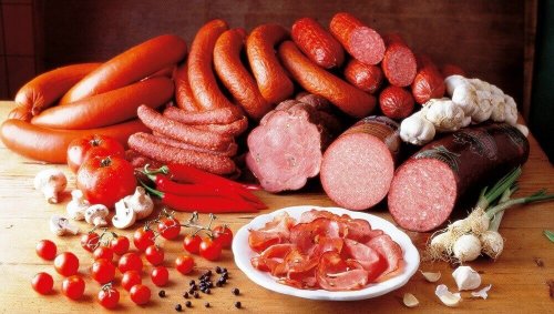 Снимка на различни видове колбаси и меса на маса