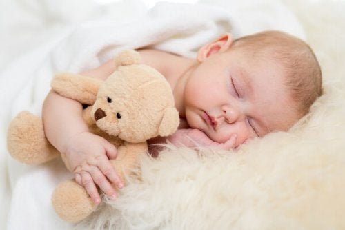 Сънят на детето: едно спящо бебе с плюшено мече