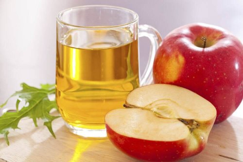 Ябълков оцет в чаша и една цяла и една полинка ябълка