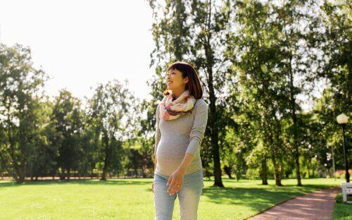 По време на бременност: една млда жена на разхоска в парк