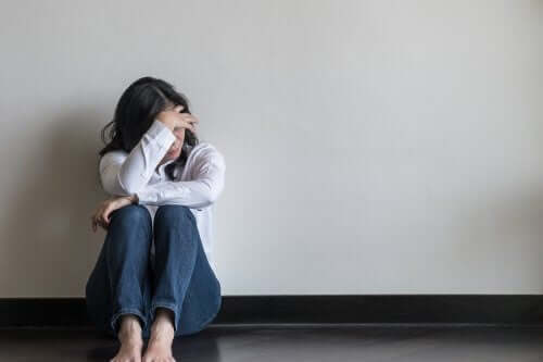 Чувството за безпокойство: снимка на една разтревожена жена, седнала на пода