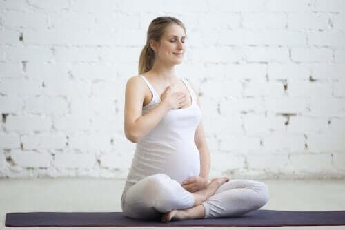 Една млада бременна жена прави йога