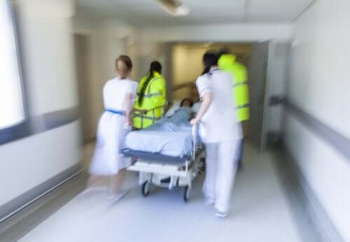 Индукцията на бързата последователност: снимка на лекари в бърза помощ, които бутат количка с пациент
