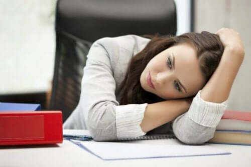Скритите навици: снимка на една млада жена, която лежи на бюрото