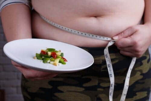 Опасните диети: снимка на дебел човек, който държи малка порция храна