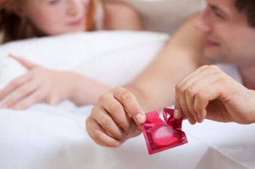 Пълноценен и безопасен сексуален живот: мъж отваря кондом