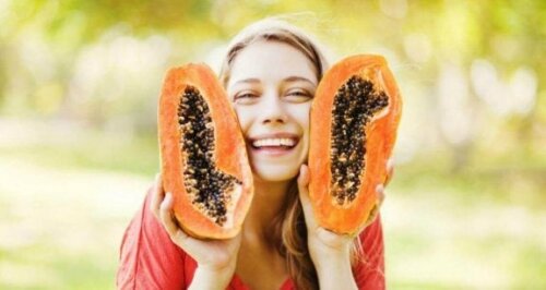Здравословни ползи от папаята: усмихнато момиче държи две парчета от папая