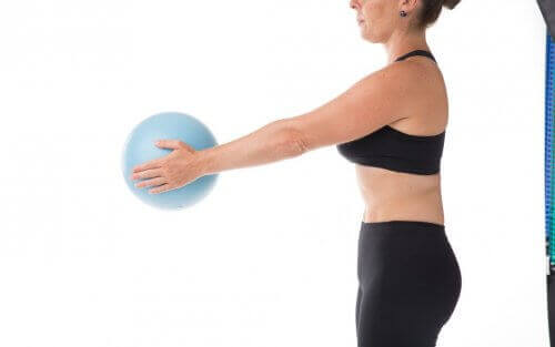 Жена държи топка и прави упражнения