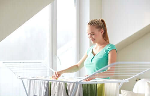 Жена простира дрехи на сушилна