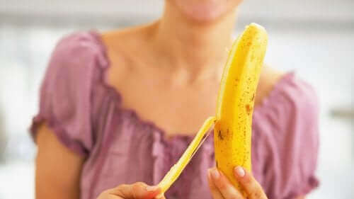 Една млада жена обелва един банан