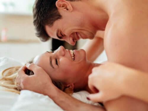 Мъж и жена се смеят и са в леглото интимно