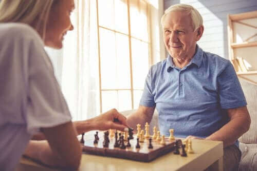 Жена и възрастен мъж играят шах