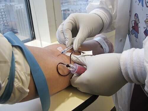 Лекар прилага интравенозно лечение на пациент