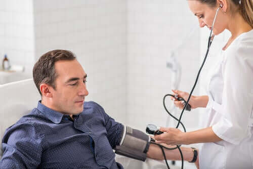 Лекарка измерва кръвното налягане на един мъж