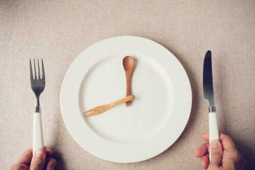 Как да ядете по-малко: бяла чиния празна, лъжица и вилица в чинията 