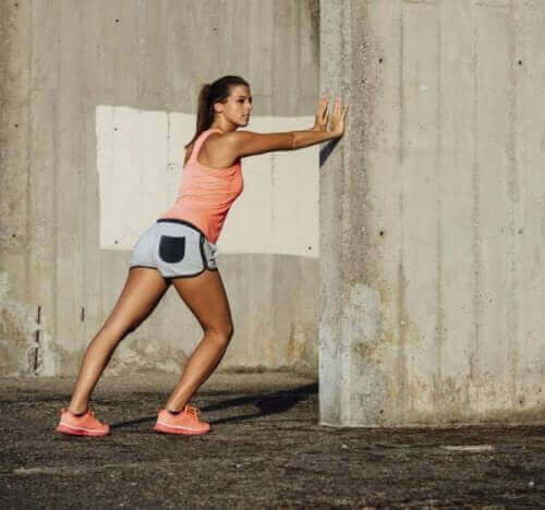 Жена прави упражнения за разтягане на прасеца.