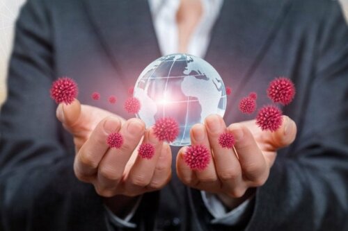 Пандемията от коронавирус: две ръце държат макет на земното кълбо и коронавируси