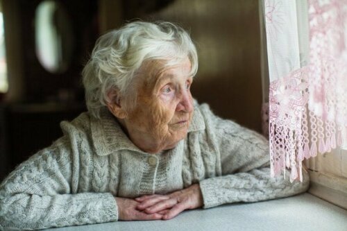 Възрастна жена, която гледа през прозореца