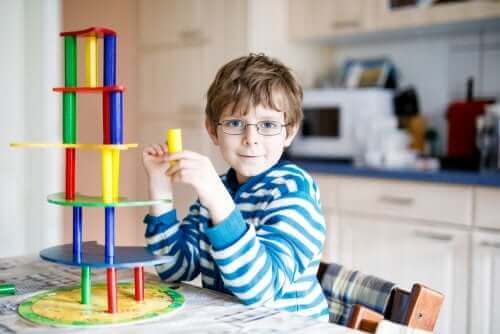 Проблеми със зрението при децата: момче с очила си играе на една маса