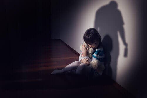 Уплашено дете седи до една стена