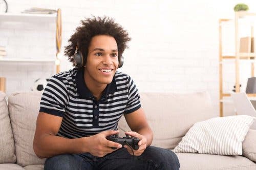 Едно момче се усмихва и играе на видео игра