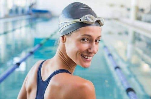 Увреждането на косата с хлор: жена плувкиня, която се готви да скочи в басейн