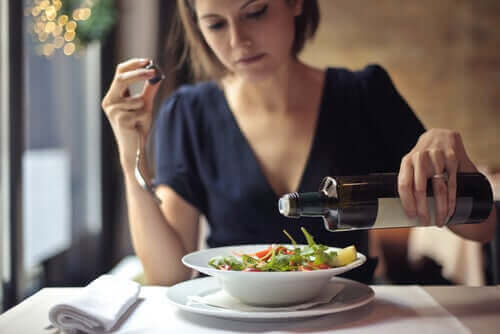 Пропускането на вечерята: една жена слага зехтин на салата