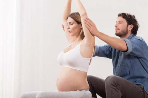 Бременна жена прави упражнения